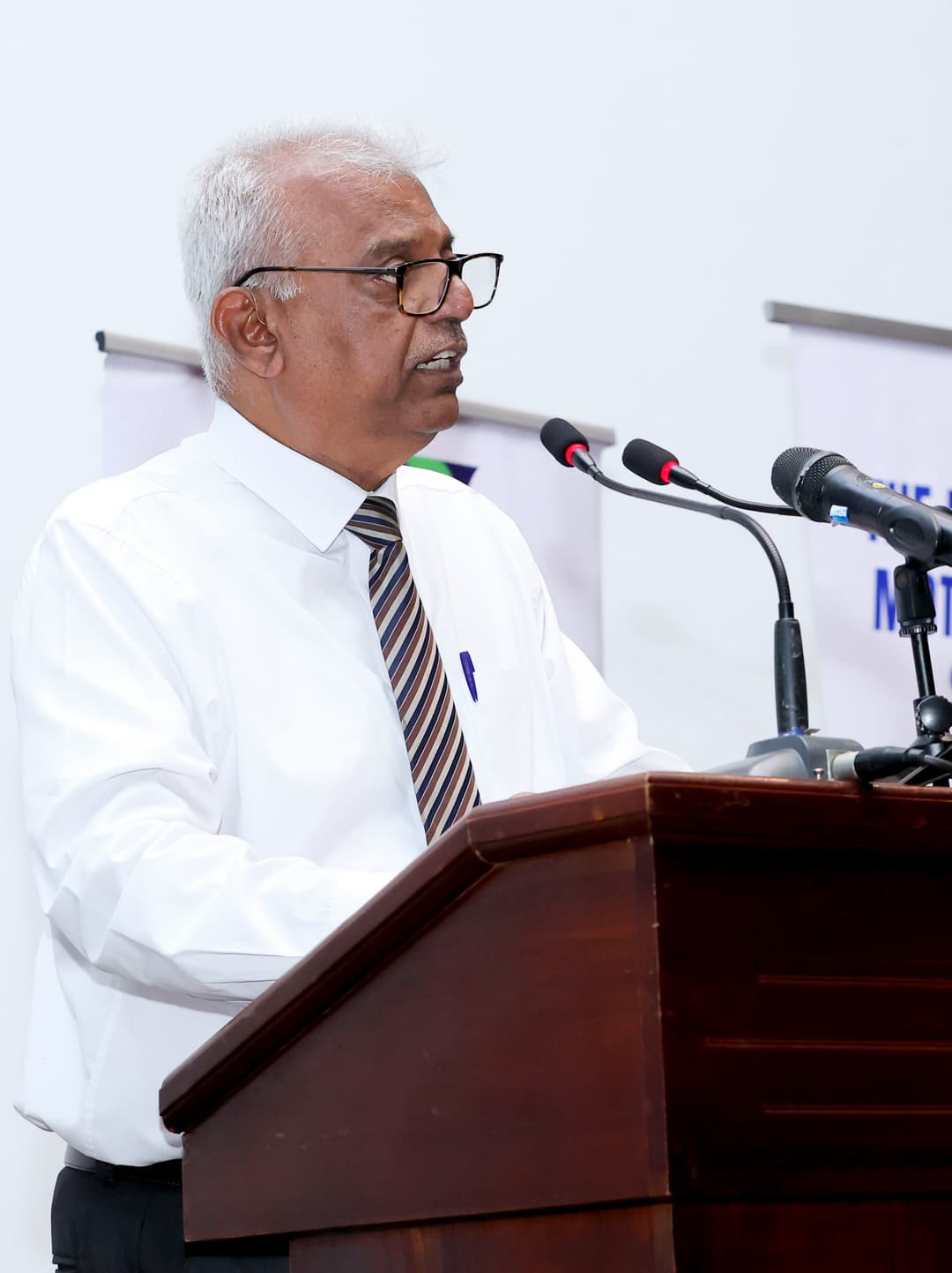 A speaker delivering a speech at a podium during a formal event